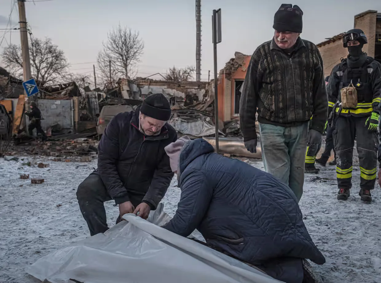 Пожежник спостерігає, як мати та батько жінки, яка загинула внаслідок ракетного обстрілу, оплакують її тіло (квітень 2025 р.).